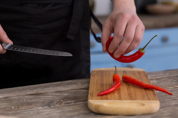 Man cutting hot chili pepper