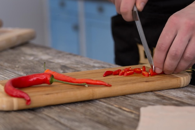 Man cutting hot chili pepper