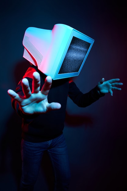 Man cyberpunk with a monitor instead of a head, computer addiction and zombie TV. Zombification, TV on your head. The influence of TV on the brain, virtual reality