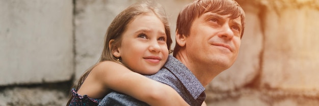 Man dad having quality time with their kid daughter girl nine year old on his back happy father playing child real life authentic daytoday fatherhood moments fatherly love care banner flare