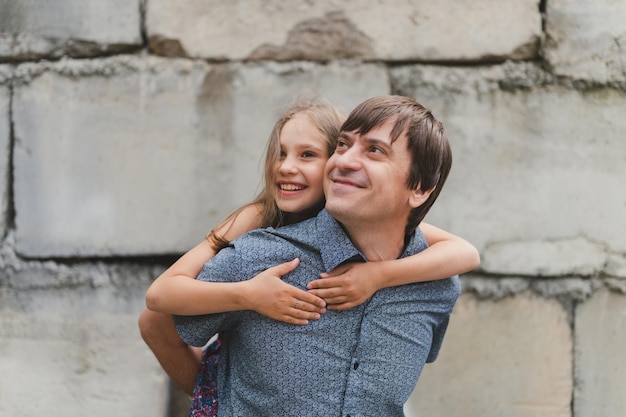 Man dad having quality time with their kid daughter girl nine year old on his back happy father playing with child real life authentic daytoday fatherhood moments fatherly love care and affection