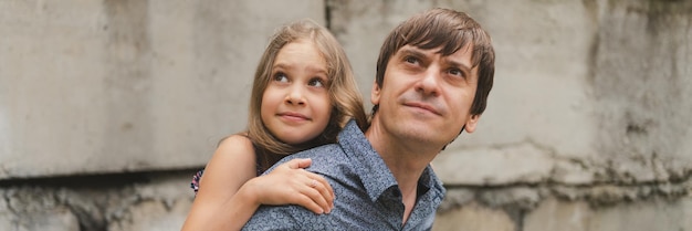 Man dad having quality time with their kid daughter girl nine year old on his back happy father playing with child real life authentic daytoday fatherhood moments fatherly love care banner