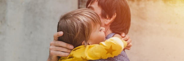 Man dad having quality time with their kid son boy six year old hug on arms happy father playing together child real life authentic daytoday fatherhood moments fatherly love care banner flare