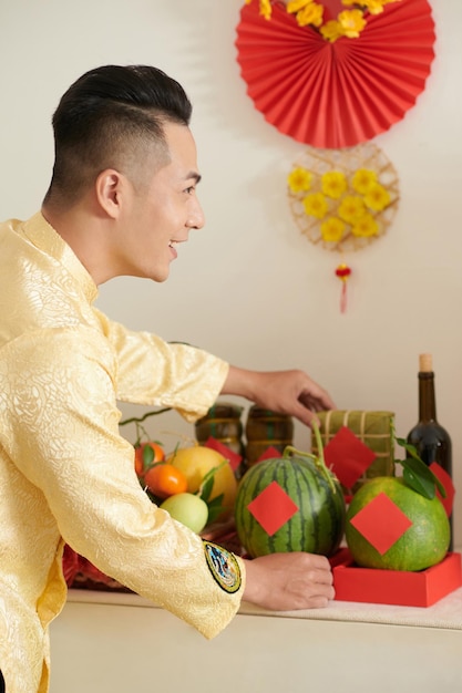 Man Decorating House for Tet