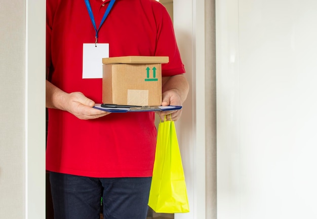 A man delivered and holds cardboard boxes and a yellow package Online shopping and express delivery