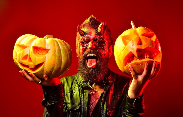 Man demon with pumpkins on red background Halloween concept Funny character comic Dracula Portrait o