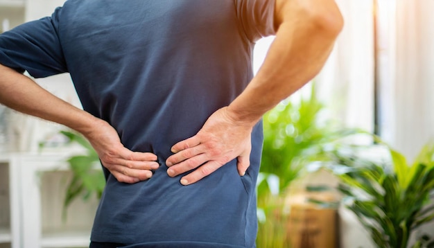 Man in discomfort holds lower back signifying back pain and healthcare concern