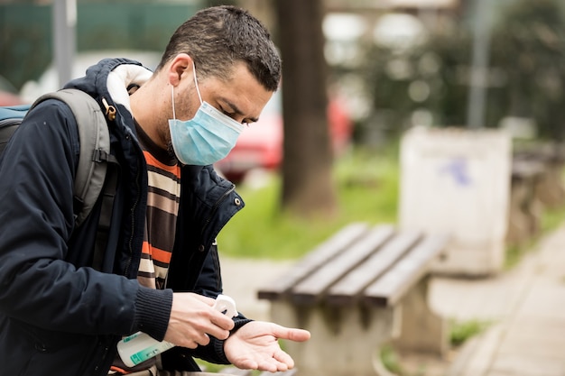 Man disinfecting his hands due to coronavirus risk