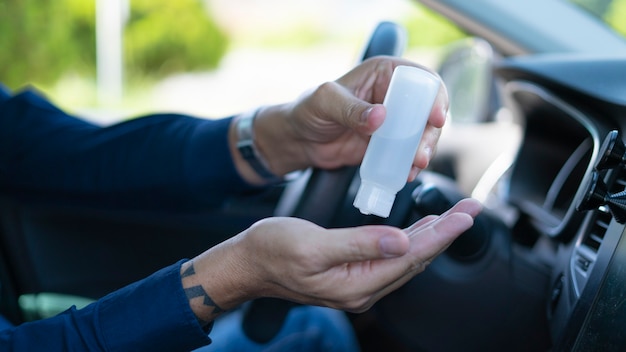 man disinfecting your hands inside the car