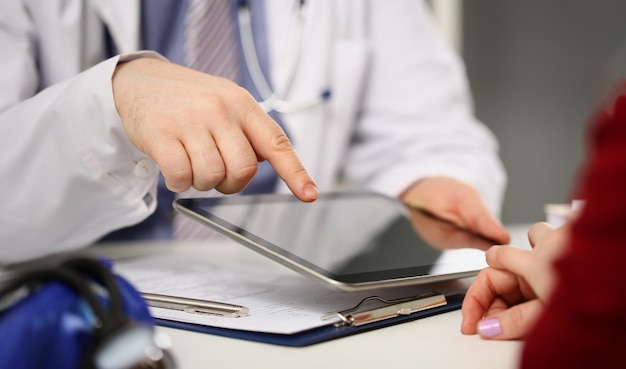 Man doctor consult woman patient point with finger on tablet device