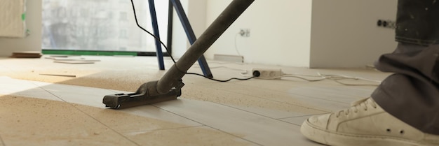 Man does industrial cleaning in room using modern vacuum cleaner male person vacuums dirty