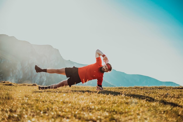 A man doing abs exercises on top of a mountain.