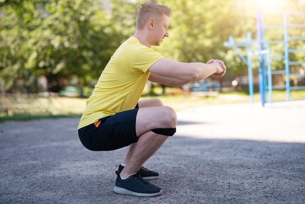 Man doing squat in knee support bandage