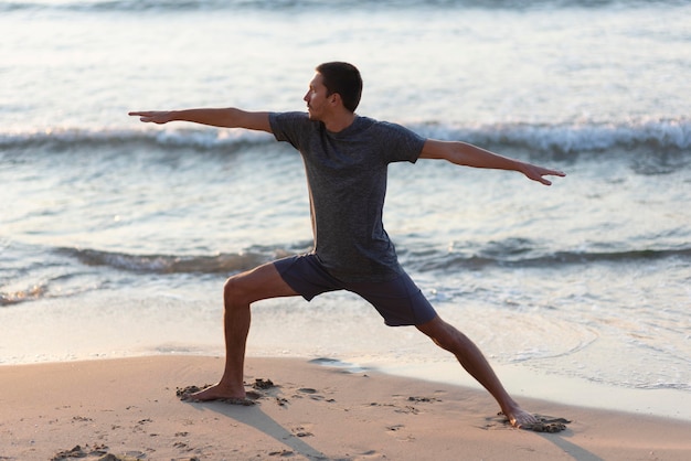 Man doing yoga on beach