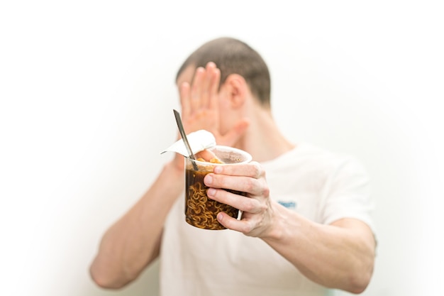 Man dont want to look on fast food noodles transparent plastic cup on a white background.