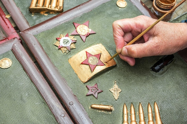 A man draws a decorative buckle with a red star from a soldier's belt of the Soviet army