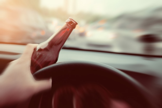 Man drink beer while driving car, Driving in a state of intoxication, don't drink and drive concept