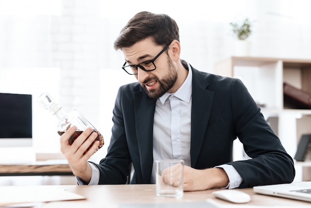 Man drinking an alcoholic drink in the workplace.