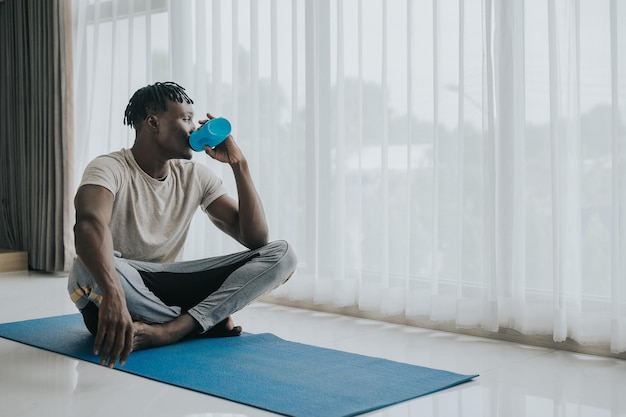 Man drinking water after exercise at home