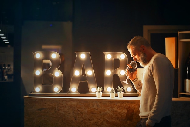 man drinks wine in a bar