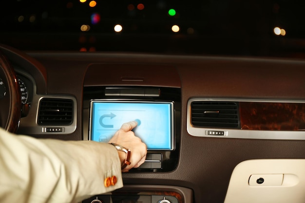 Man driving his modern car at night in city closeup