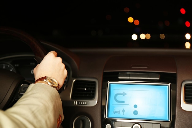 Man driving his modern car at night in city closeup