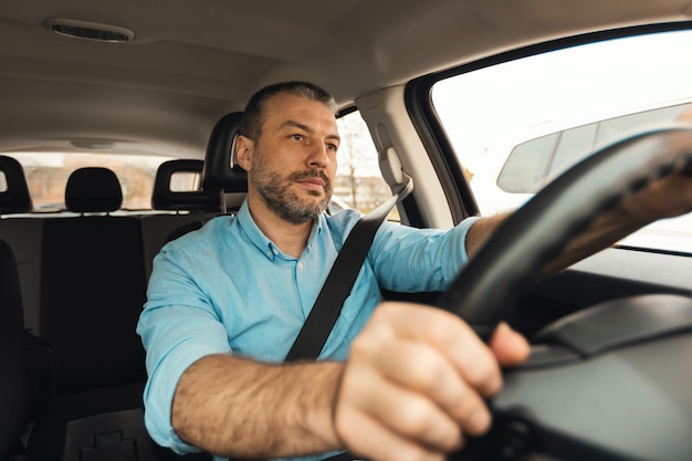 Man driving new car sitting inside automobile riding in city