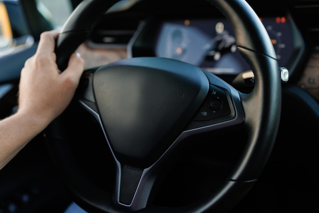 Man driving with one hand on steering wheel male hand hold a steering wheel confidently driving