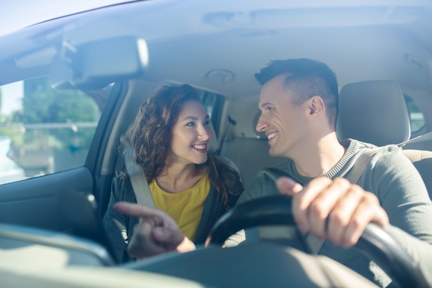 Man driving and next to woman are both wearing seat belts