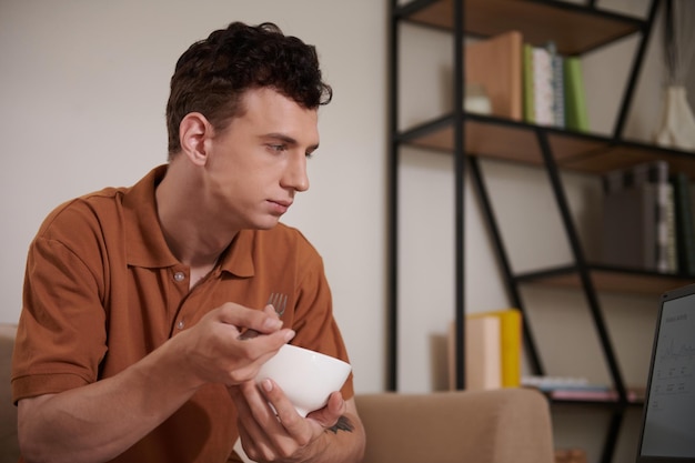 Man Eating and Checking Report