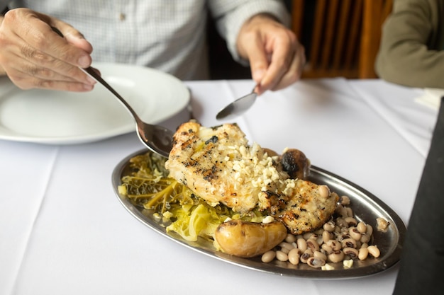 Man eating grilled cod fish in restaurante