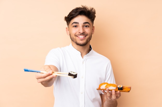 man eating sushi isolated on beige