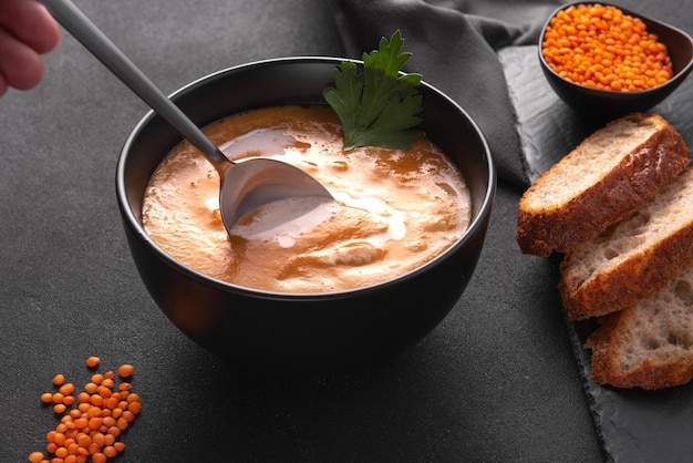 Man eats lentil soup a spoonful of lentil soup