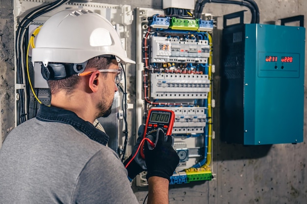 Man an electrical technician working in a switchboard with fuses