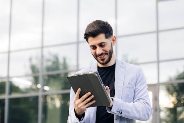 Man engaged in business using tablet computer reading financial news online european hairstyle