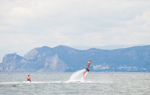 A man engaged in flyboarding on the ocean.