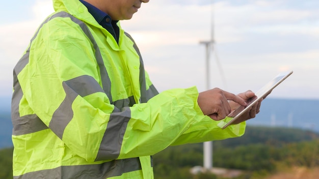 A man engineer is wearing a protective helmet on her head using tablet Analytics