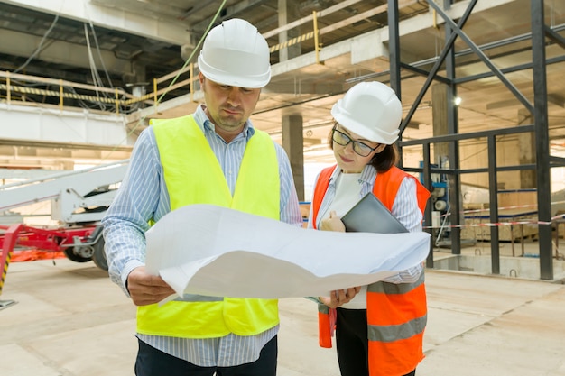 Man engineer and woman architect at a construction site