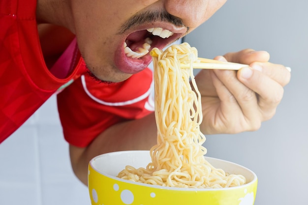 A man enjoying to eat instant noodles