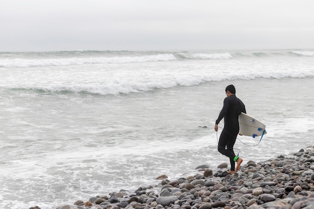 Man entering the water to surf