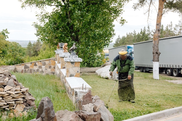 man equipped with special clothes cutting grass