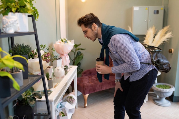 A man examines the assortment in a flower and bouquet shop before buying