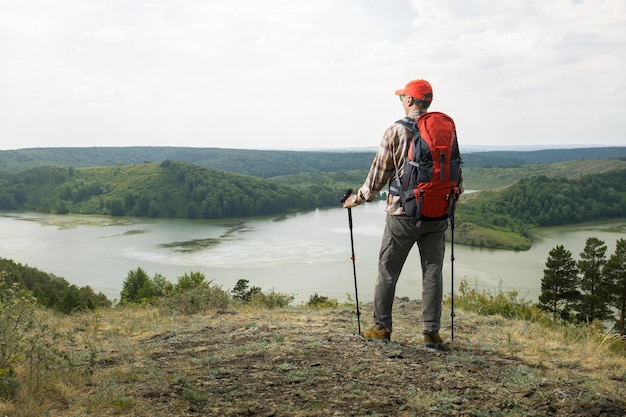 Man exercising outdoors hiking using trekking poles in countryside on a mountain Travel Lifestyle wanderlust adventure concept summer vacations outdoor