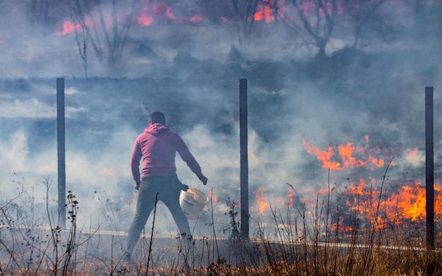 The man extinguishes the fire alone Seasonal ecological catastrophe of burning