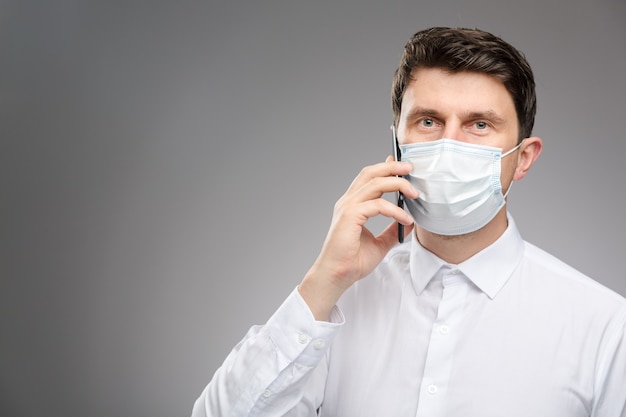 Man in face mask talking by phone