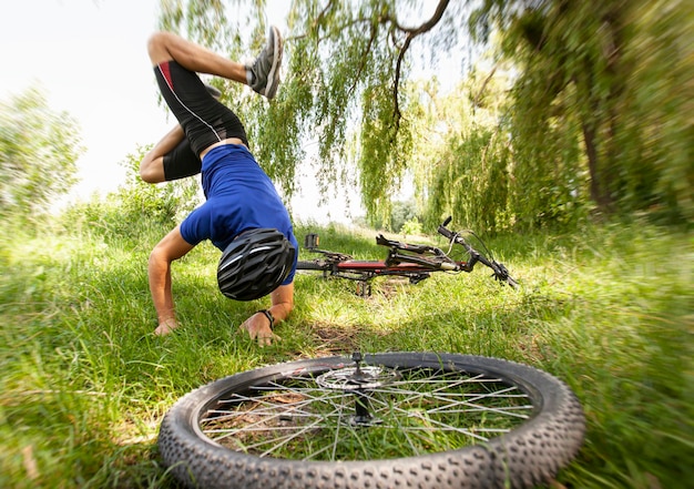 Man falling from the bike on the pathway in the countryside