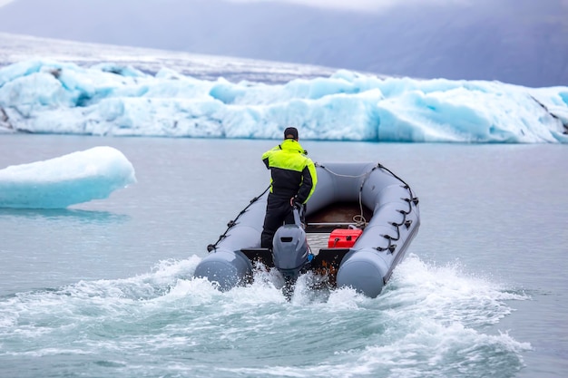 Man on a fast motor boat sailing on a glacier lagoon in Iceland