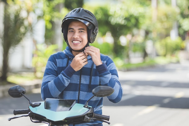 Man fastening his motorbike helmet