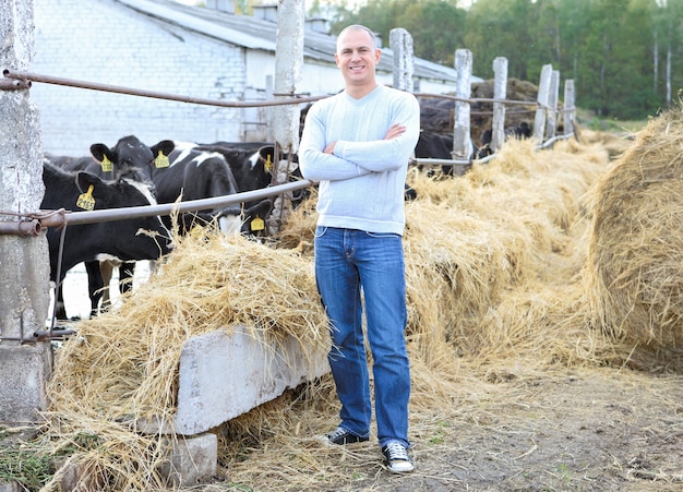 Man feeding cows on a farm outdoors