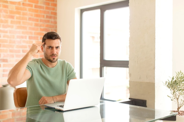 man  feeling confused and puzzled, showing you are insane, crazy or out of your mind